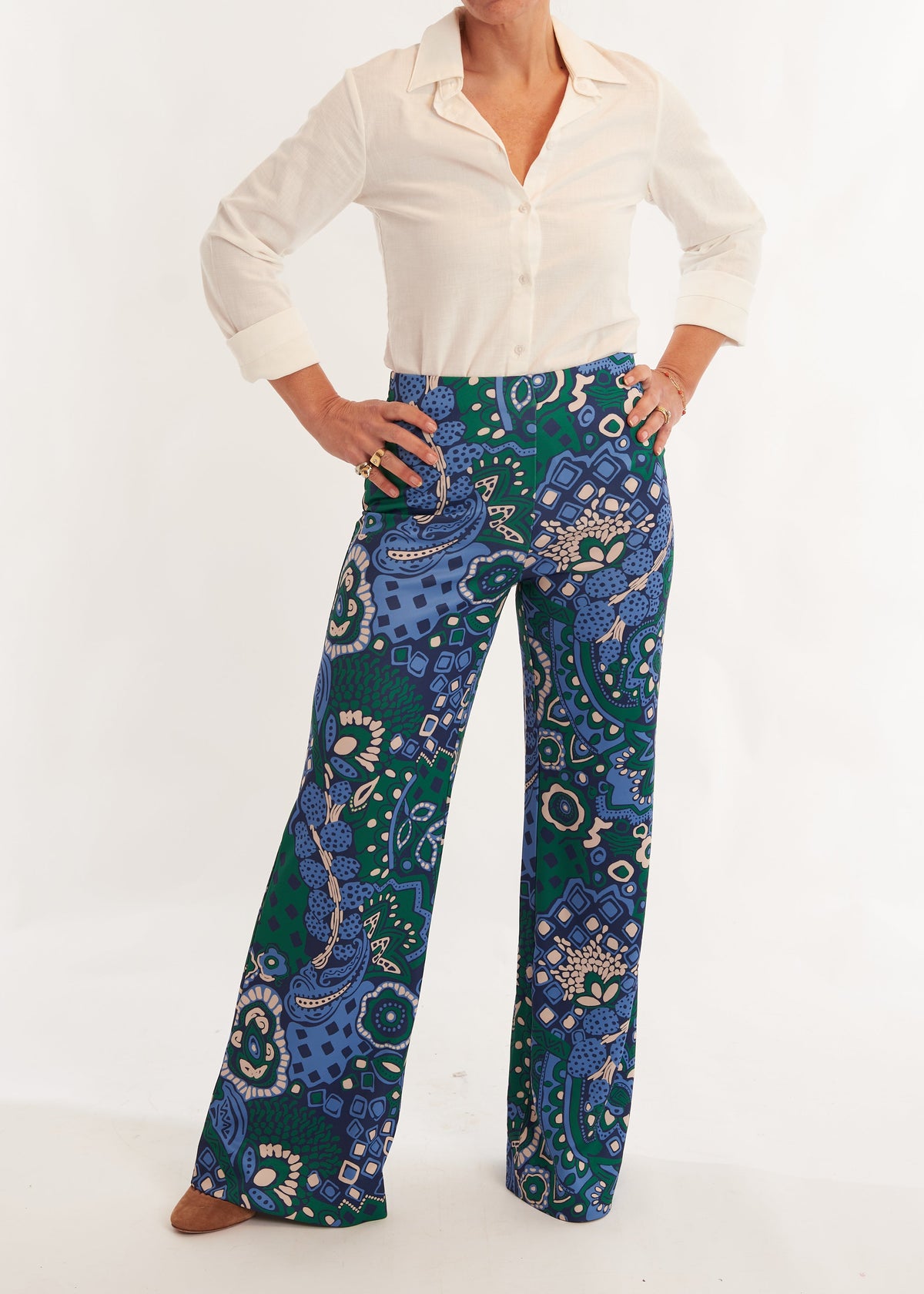 Person wearing a white shirt and blue patterned pants on a white background