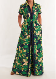 Person wearing a green and yellow floral jumpsuit on a white background