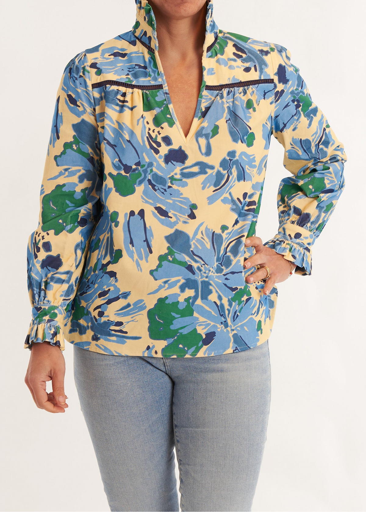 Person wearing a colorful floral jacket and light blue jeans on a white background