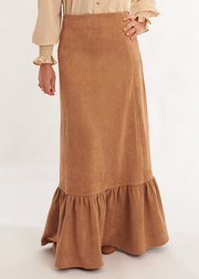 Person wearing a beige blouse and brown skirt on a white background