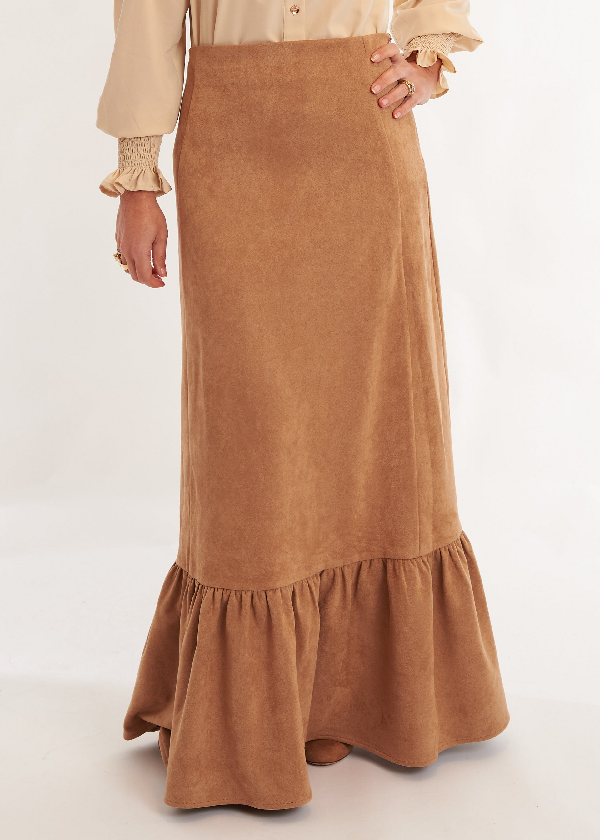 Person wearing a beige blouse and brown skirt on a white background