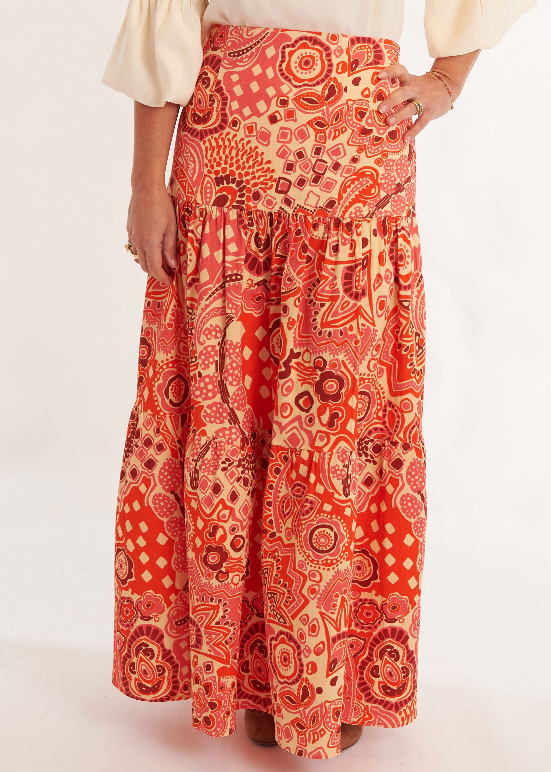 Person wearing a white blouse and red patterned skirt on a white background